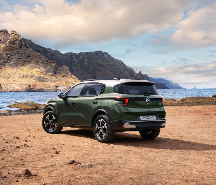 Зелений Citroën C3 Aircross на березі моря, вигляд ззаду з лівого боку